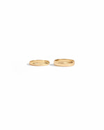 closeup image of 3mm plain gold band ring and 5mm plain eternity ring
