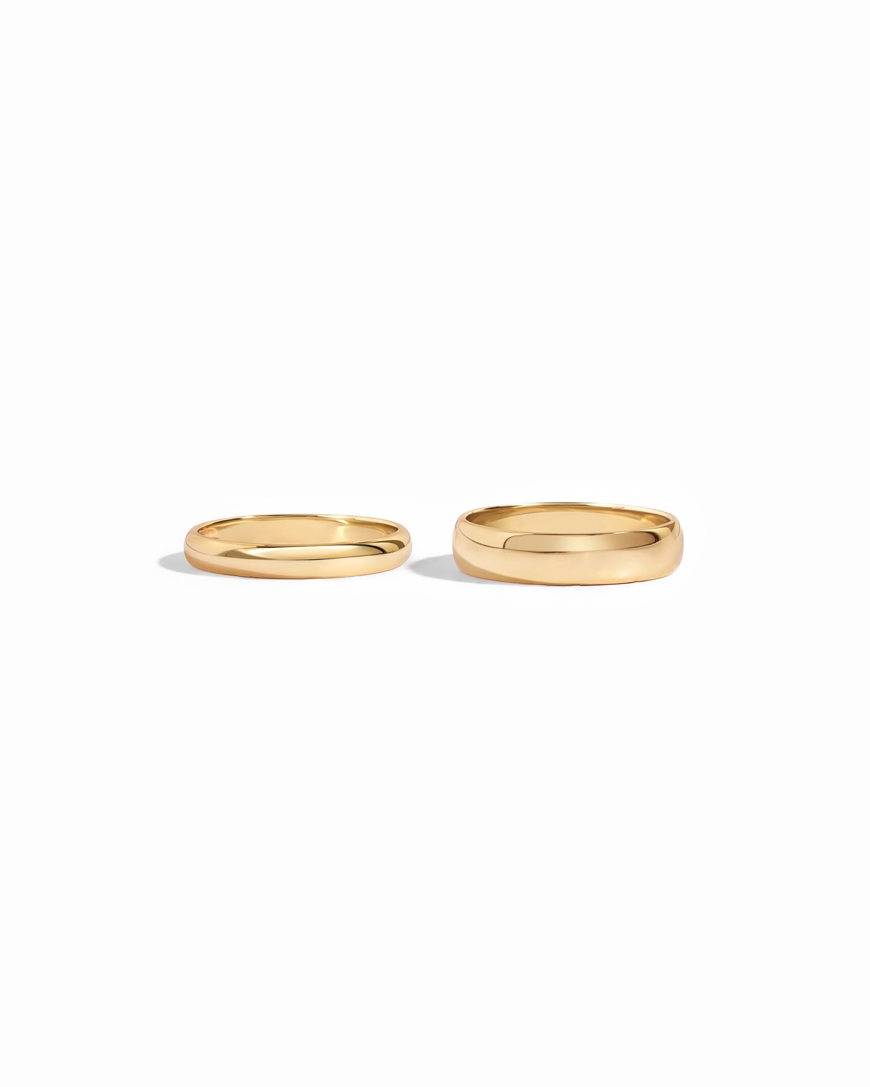 closeup image of 3mm plain gold band ring and 5mm plain eternity ring