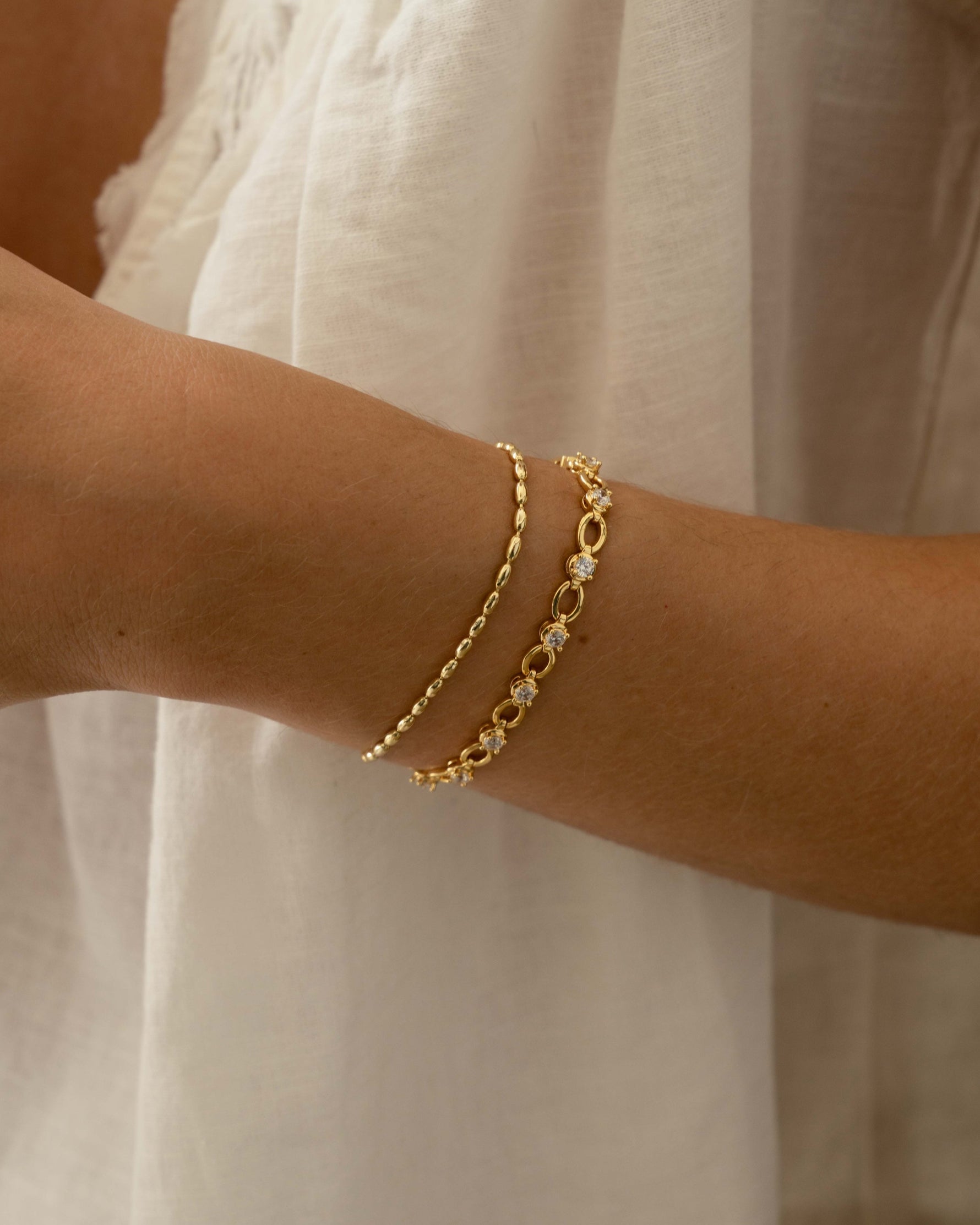 gold stacking bracelets on models wrist