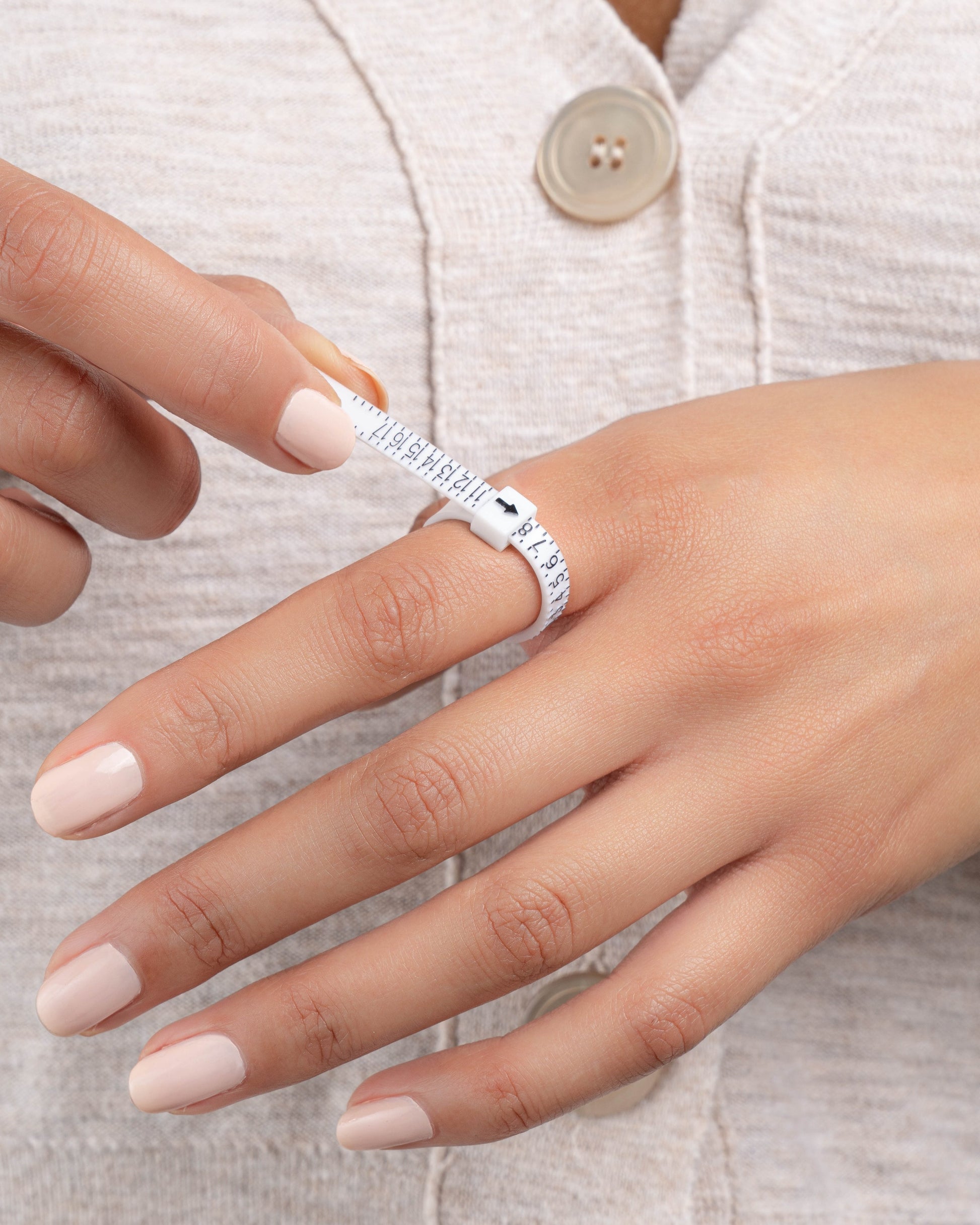 Close-up of a model wearing a ring sizer tool