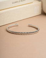 Silver vintage bracelet, also can be an arm cuff, on a beige surface