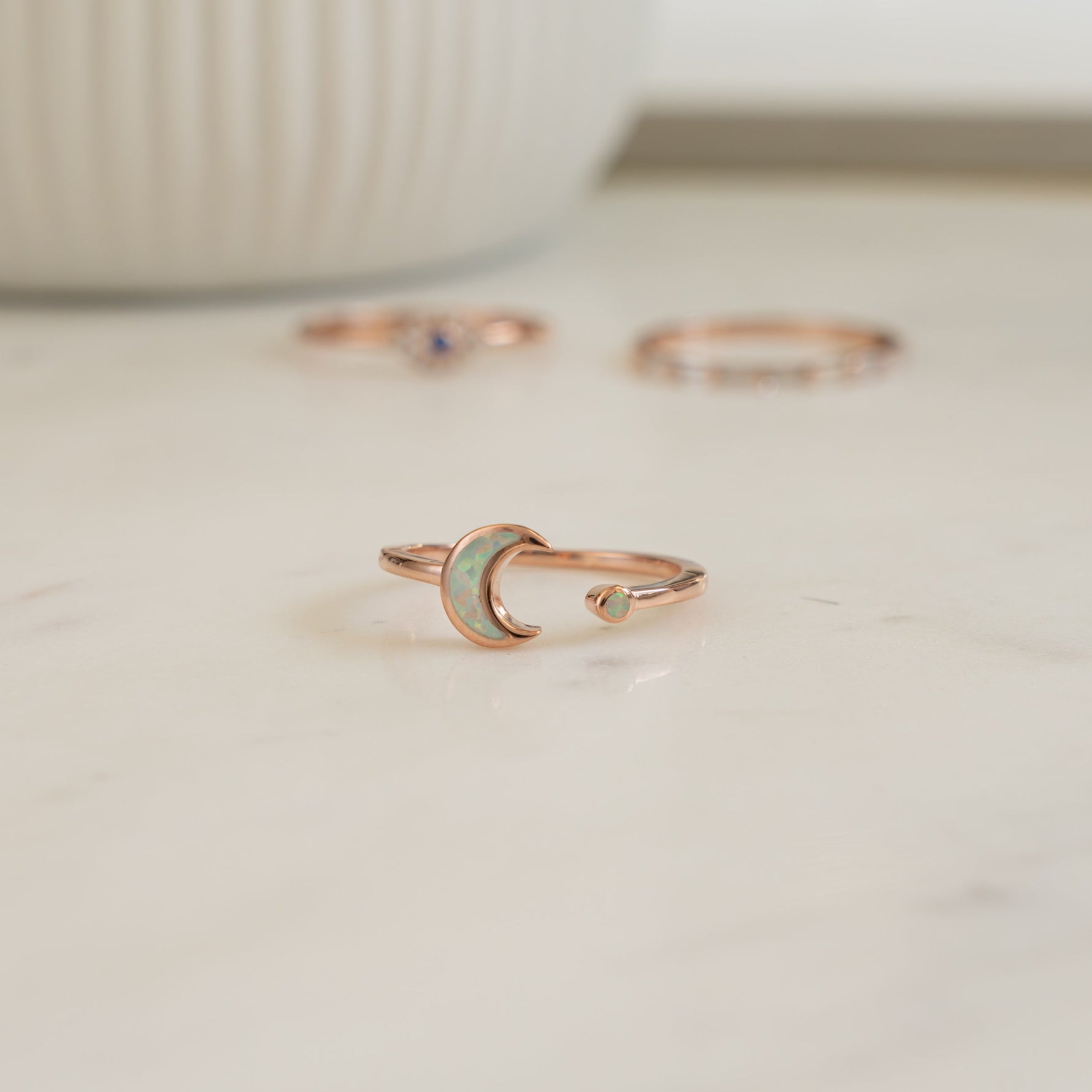 closeup image of rose gold ring featuring an opal celestial ring
