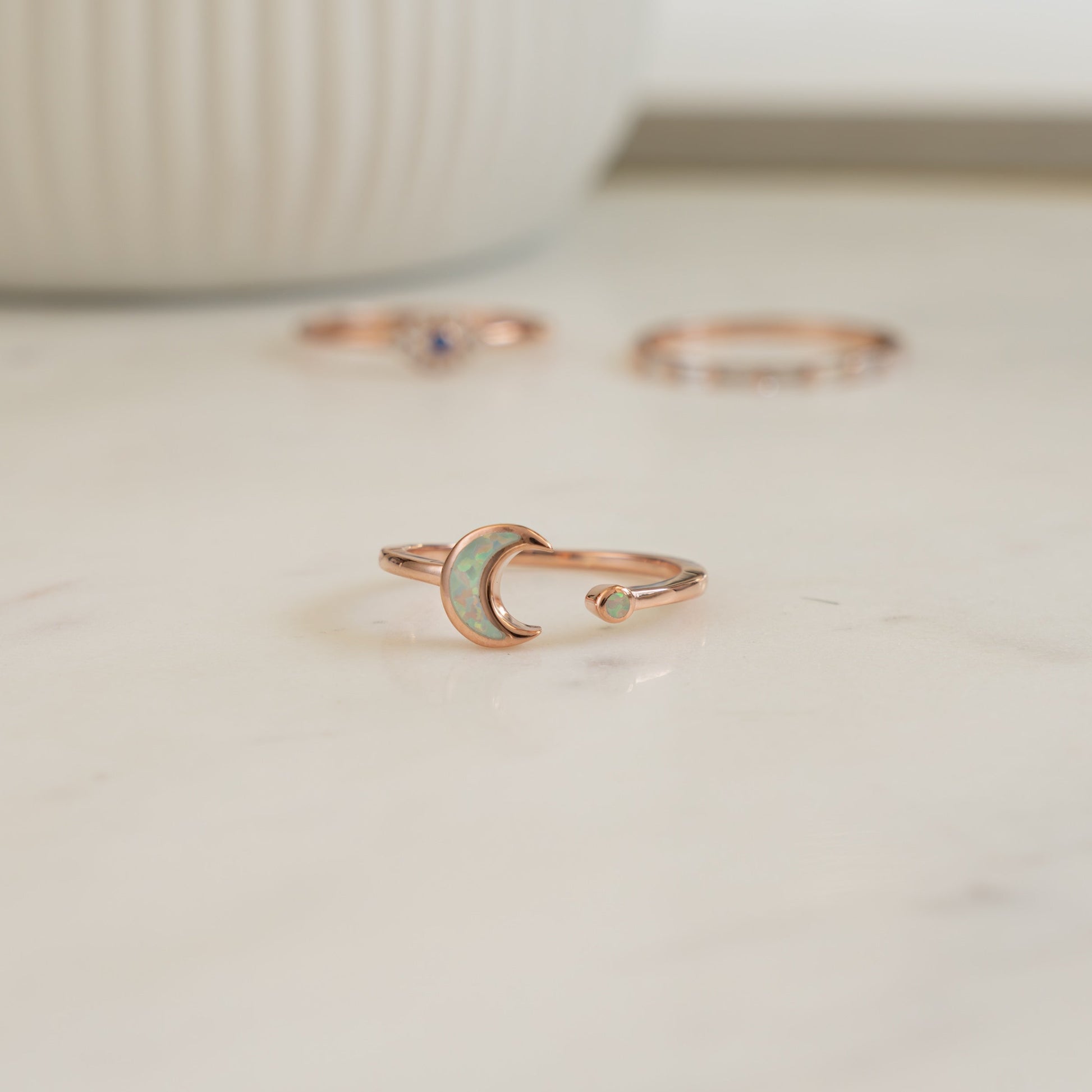 closeup image of rose gold ring featuring an opal celestial ring