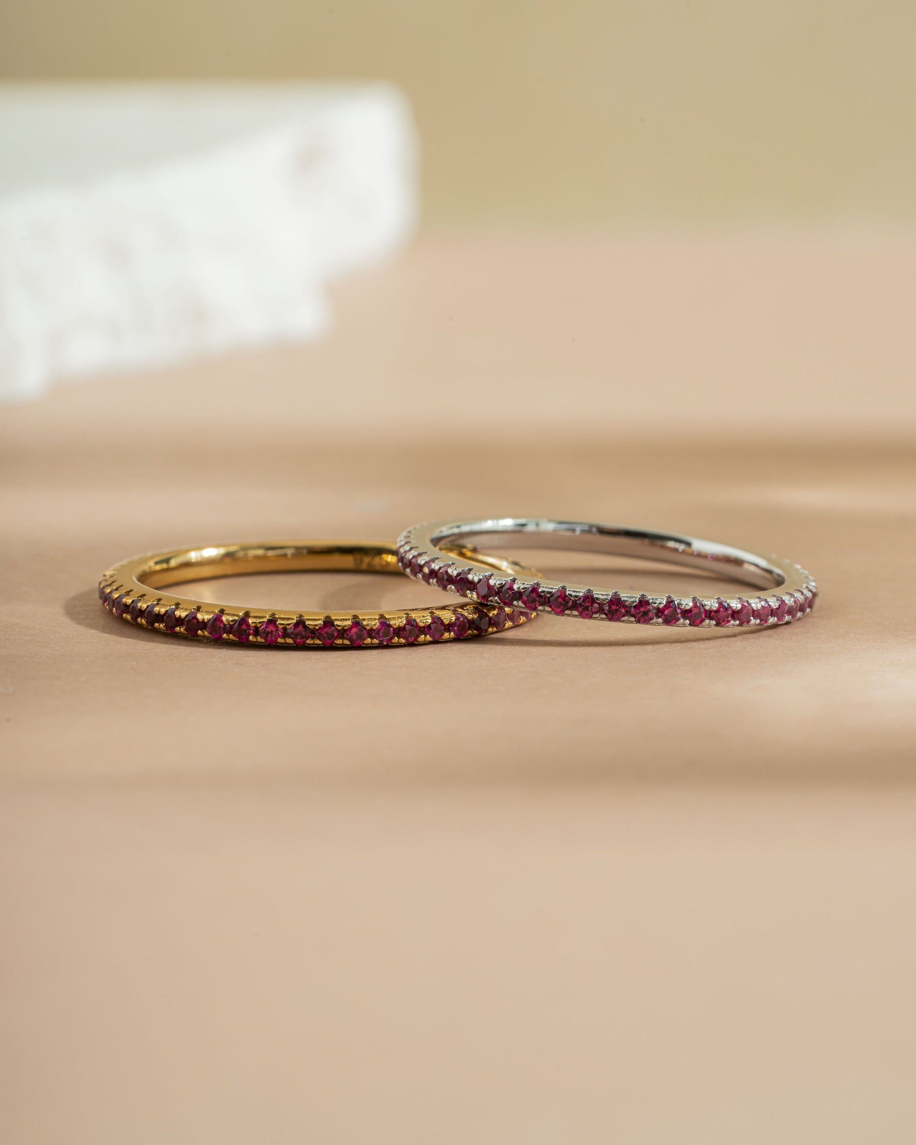 Gold eternity ring with ruby gemstones and a matching sterling silver ruby ring