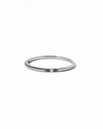 Silver ring with small ruby gemstones on a white background