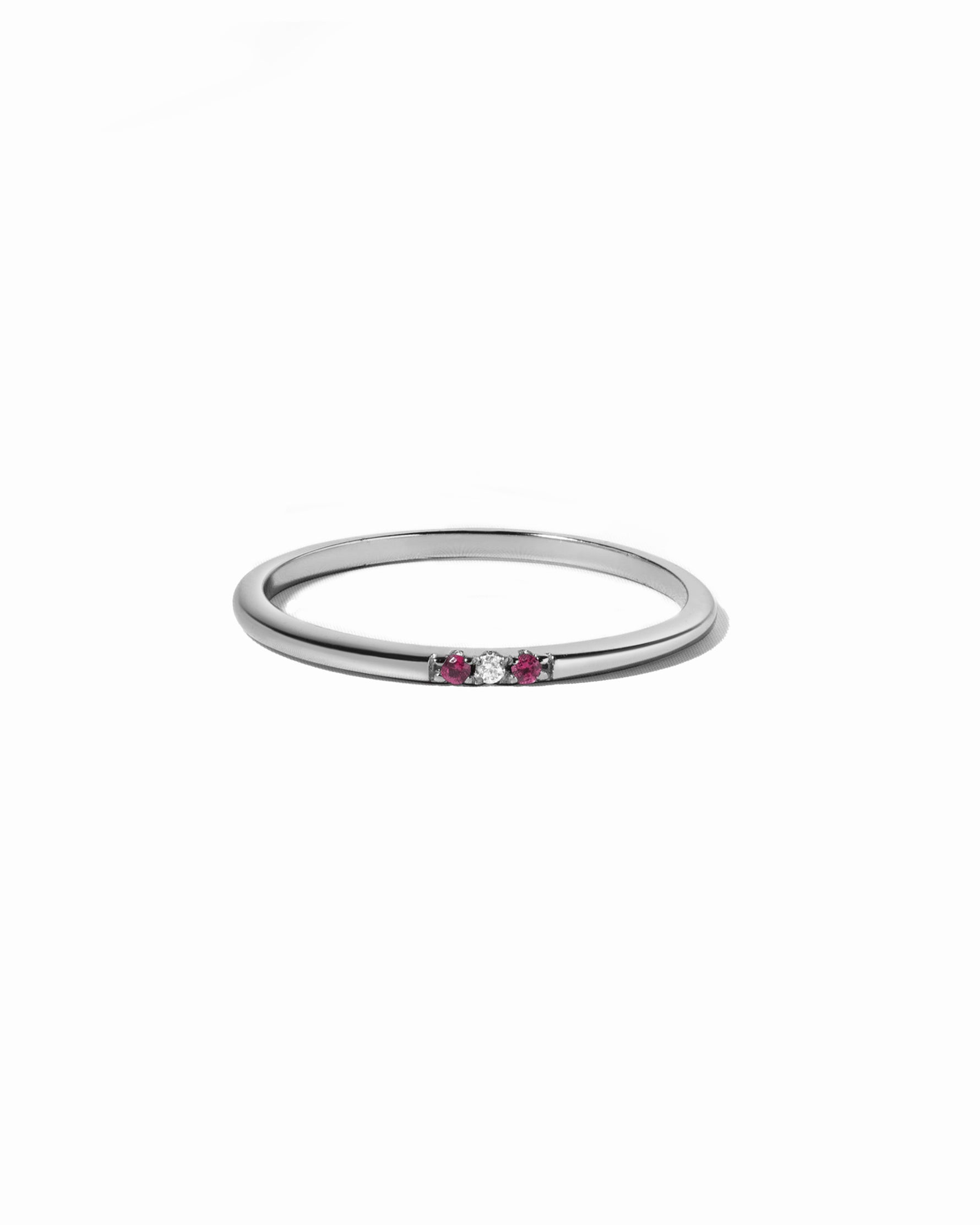 Silver ring with small ruby gemstones on a white background