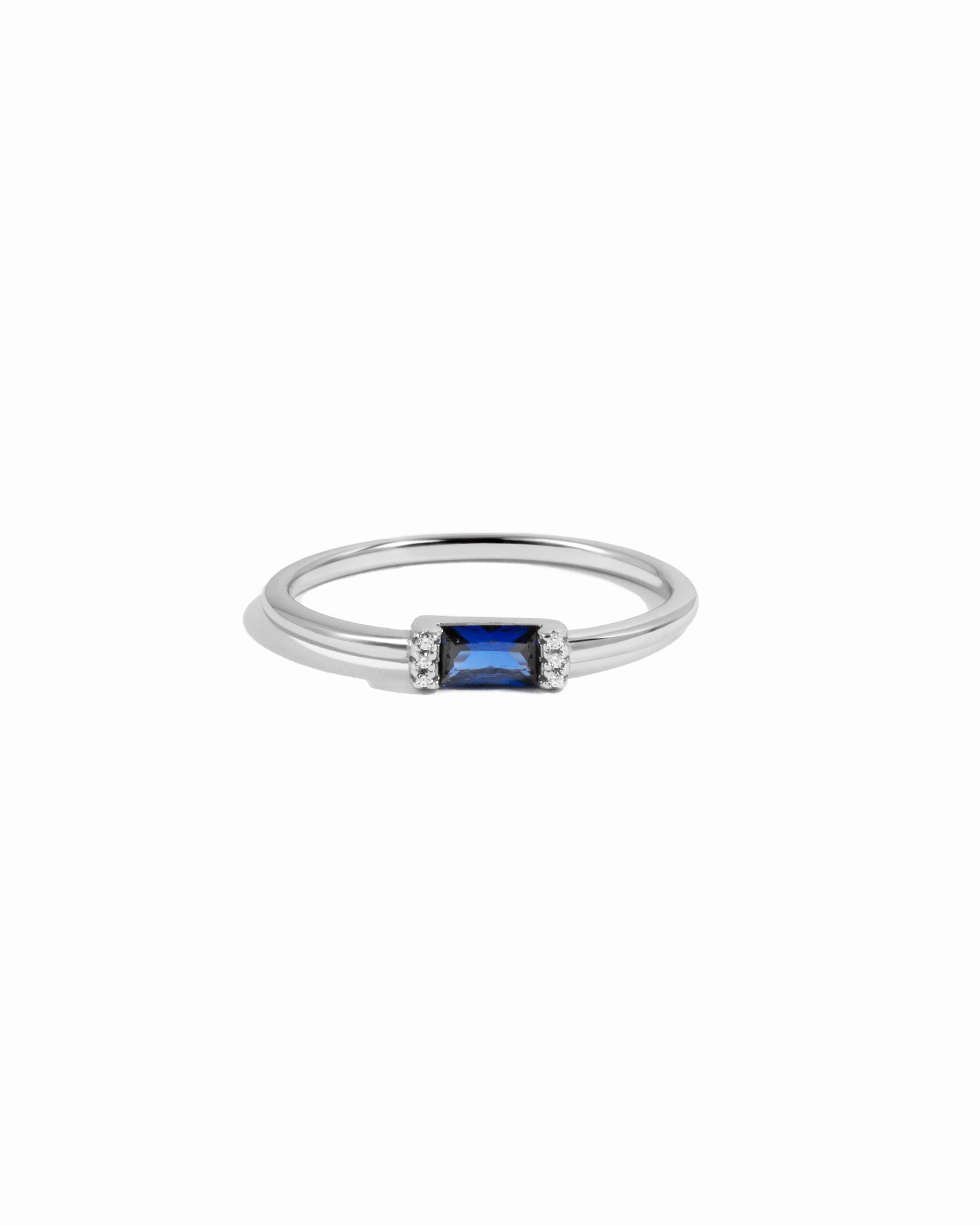 Silver ring with a sapphire baguette gemstone on a white background