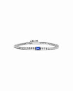 Silver bracelet with a sapphire gemstone on a white background