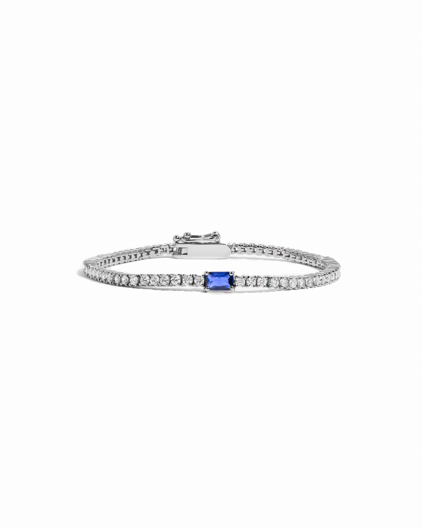 Silver bracelet with a sapphire gemstone on a white background