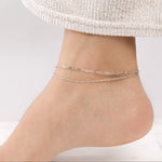 Model wearing a silver chain anklet set