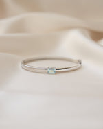 Silver bangle featuring and aquamarine gemstone
