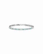 closeup image of silver tennis bracelet with aquamarine stones