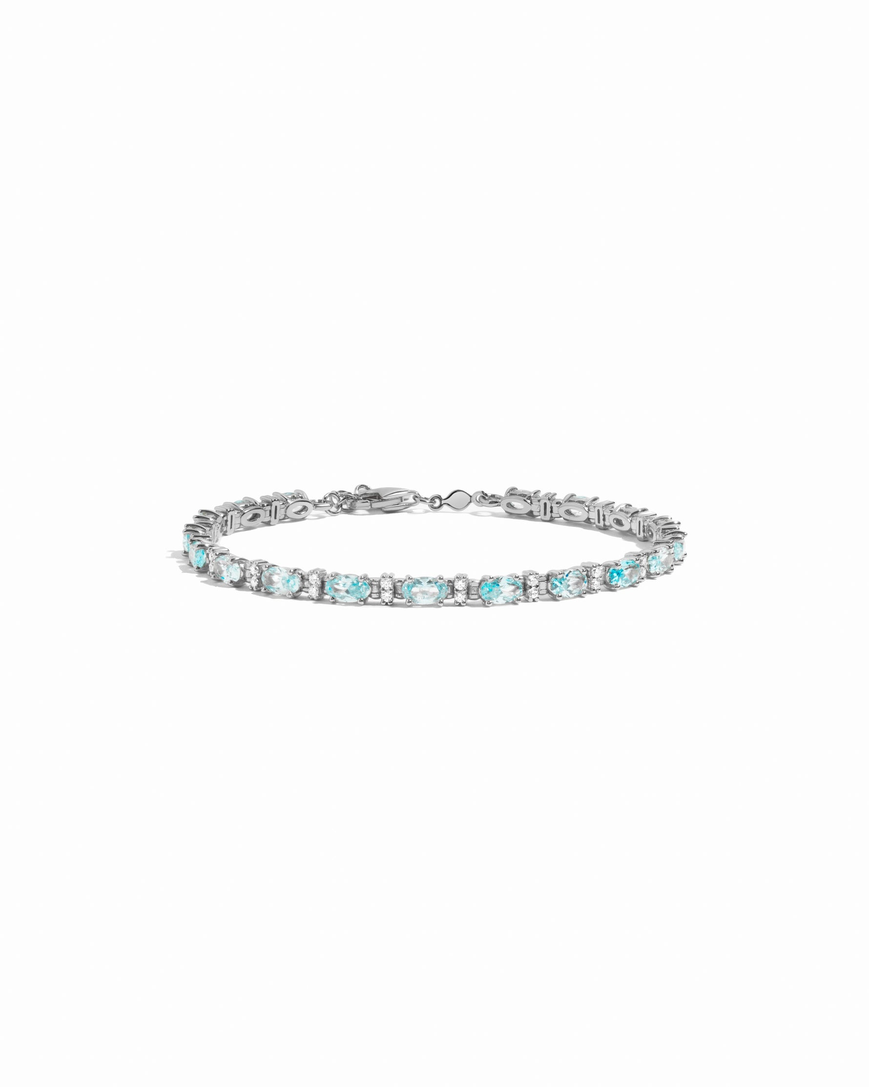 closeup image of silver tennis bracelet with aquamarine stones