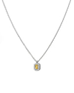 Silver chain necklace with a yellow gemstone pendant on a white background