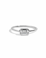 Silver ring with a baguette gemstone on a white background