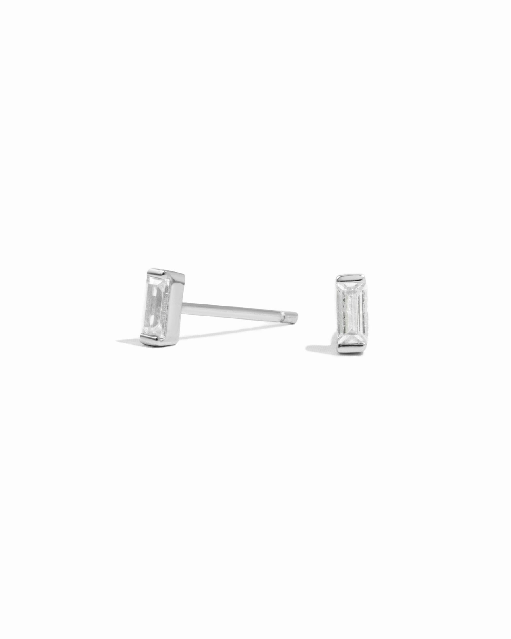 Silver baguette cut stud earrings on a white background