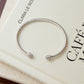 closeup image of silver open cuff bangle bracelet with cubic zirconia stones