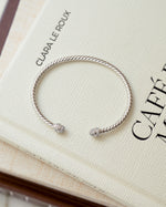 closeup image of silver open cuff bangle bracelet with cubic zirconia stones