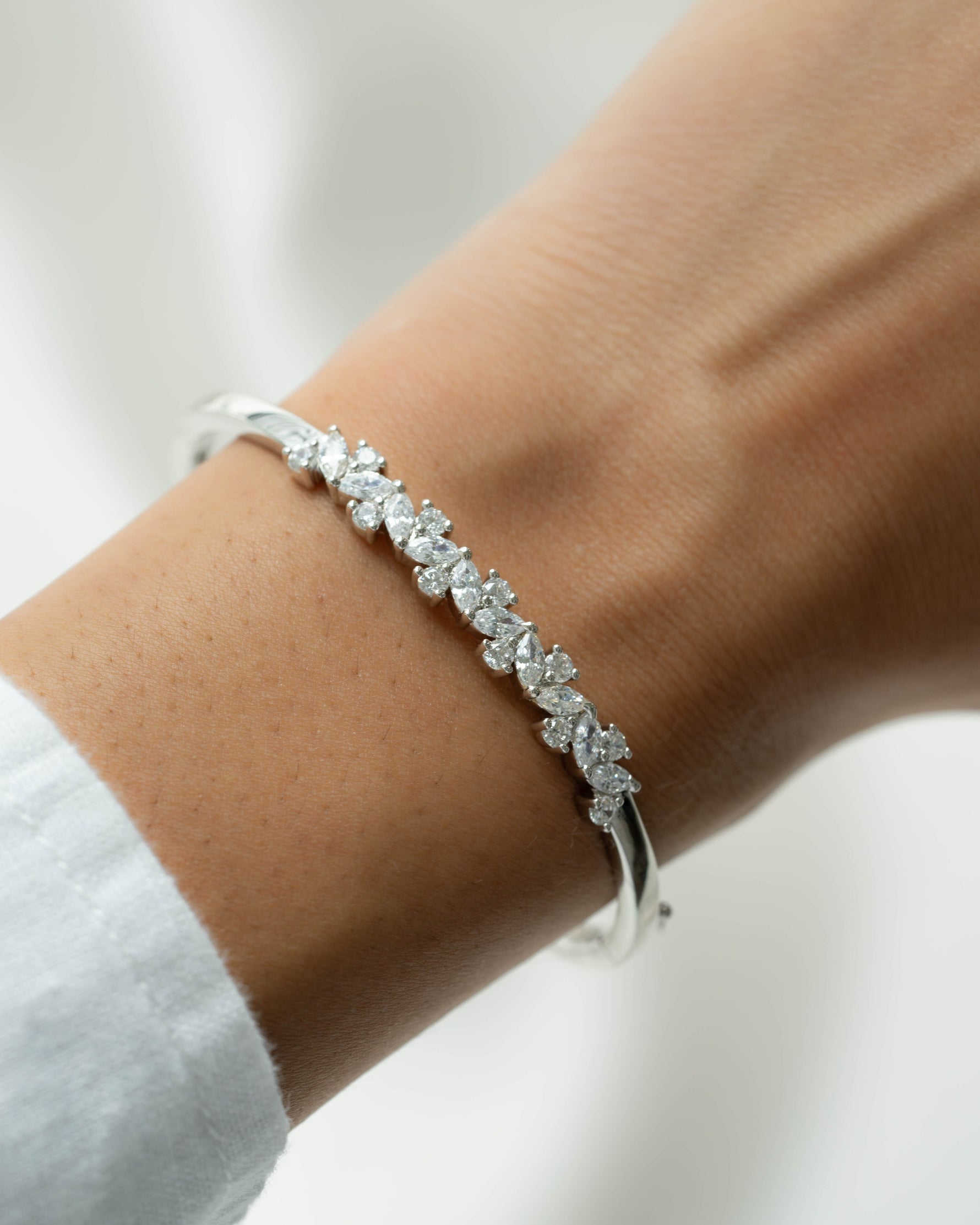 Model wearing silver diamond bracelet on a wrist with a blurred background