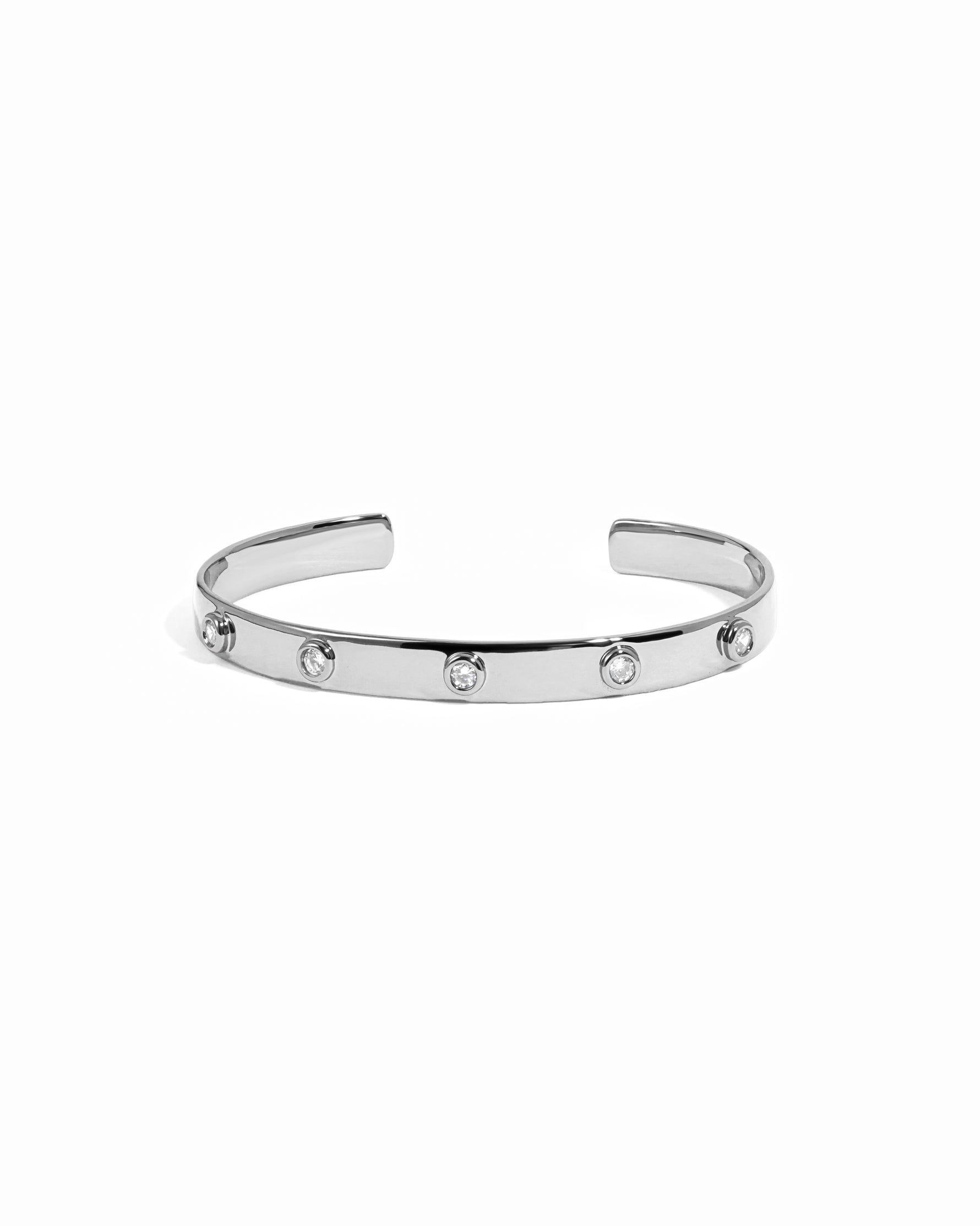 Silver cuff bracelet with small cubic zirconia stones on a white background