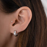 Model wearing 925 sterling silver huggie hoops with a bezel diamond