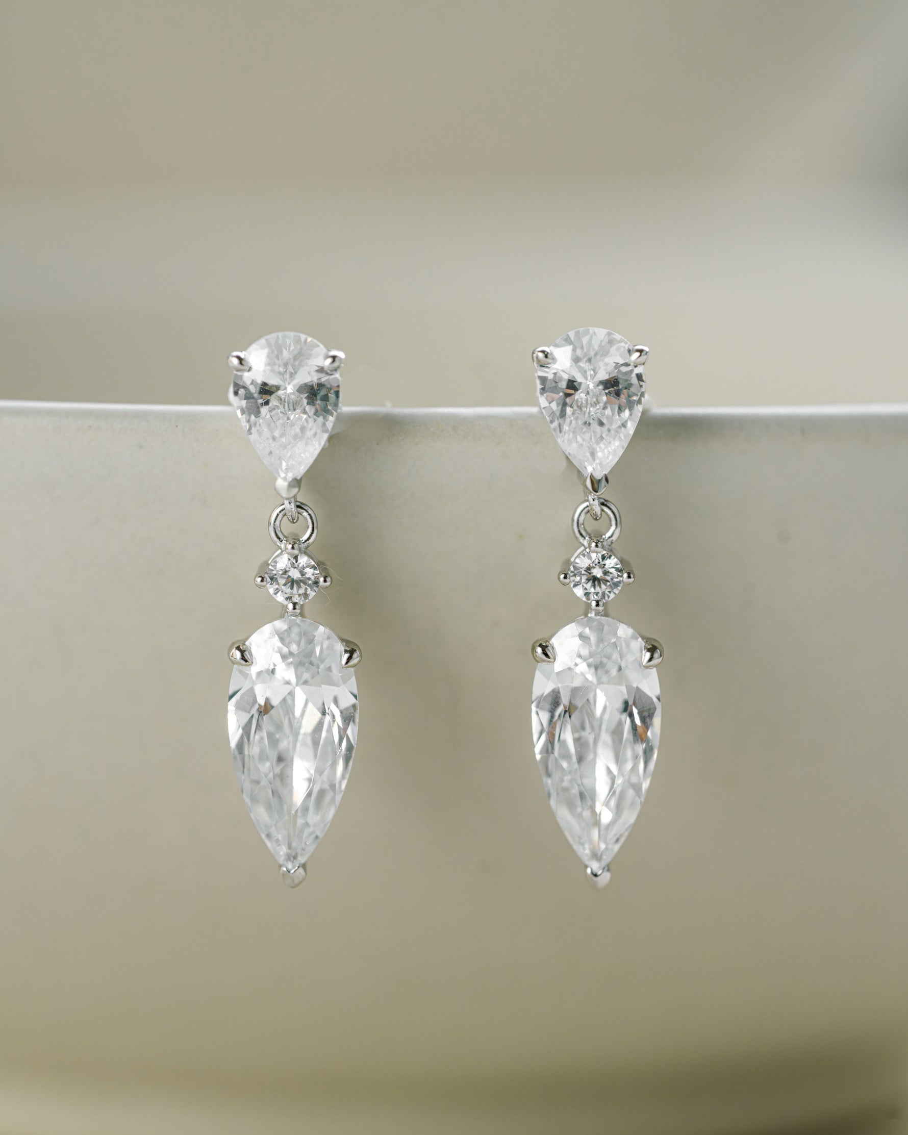 Sterling silver minimalist earrings featuring dainty drop earrings with a pear cut stone