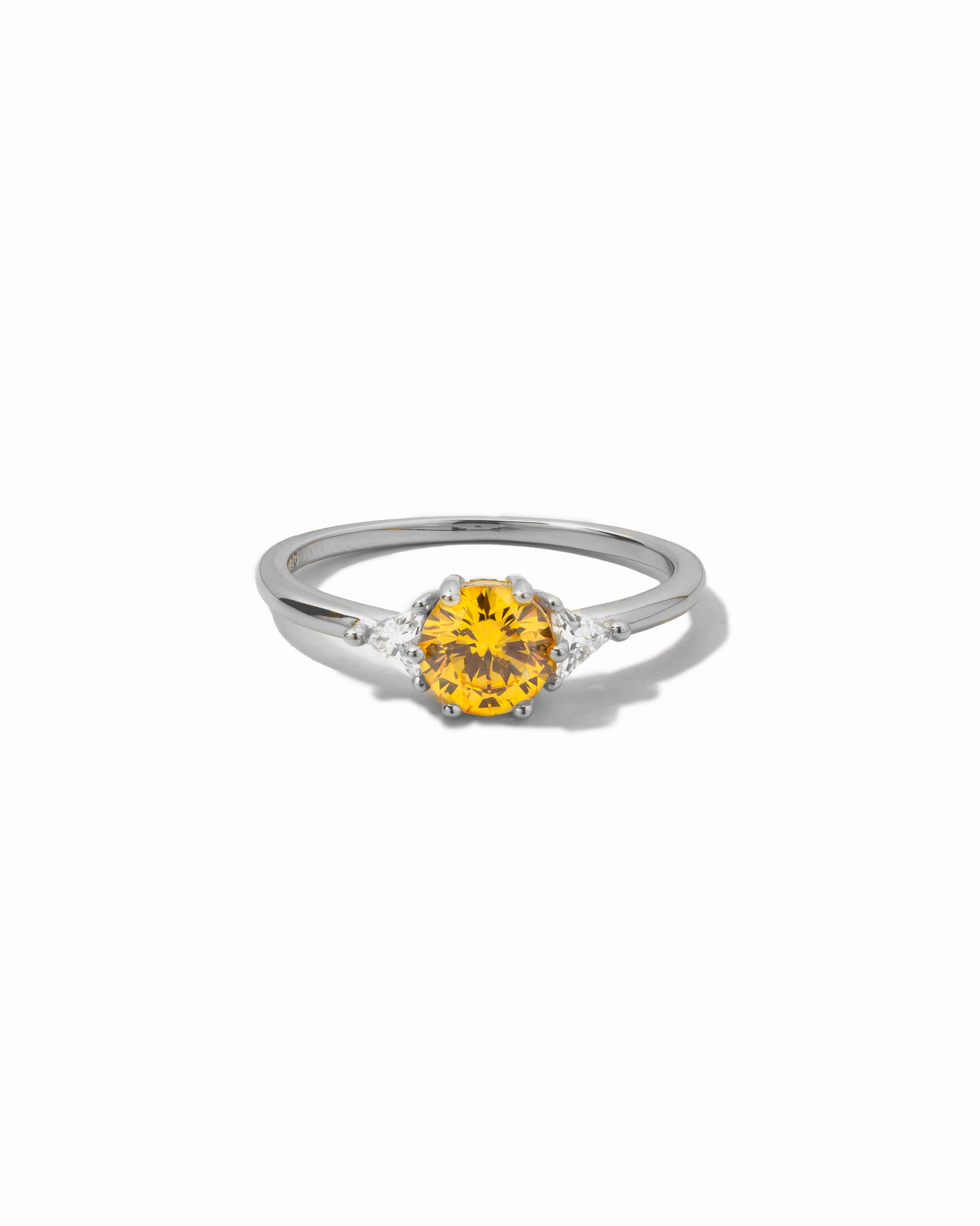 Silver statement ring with a yellow canary gemstone on a white background