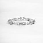closeup image of statement jewelry featuring a silver chain link bracelet 