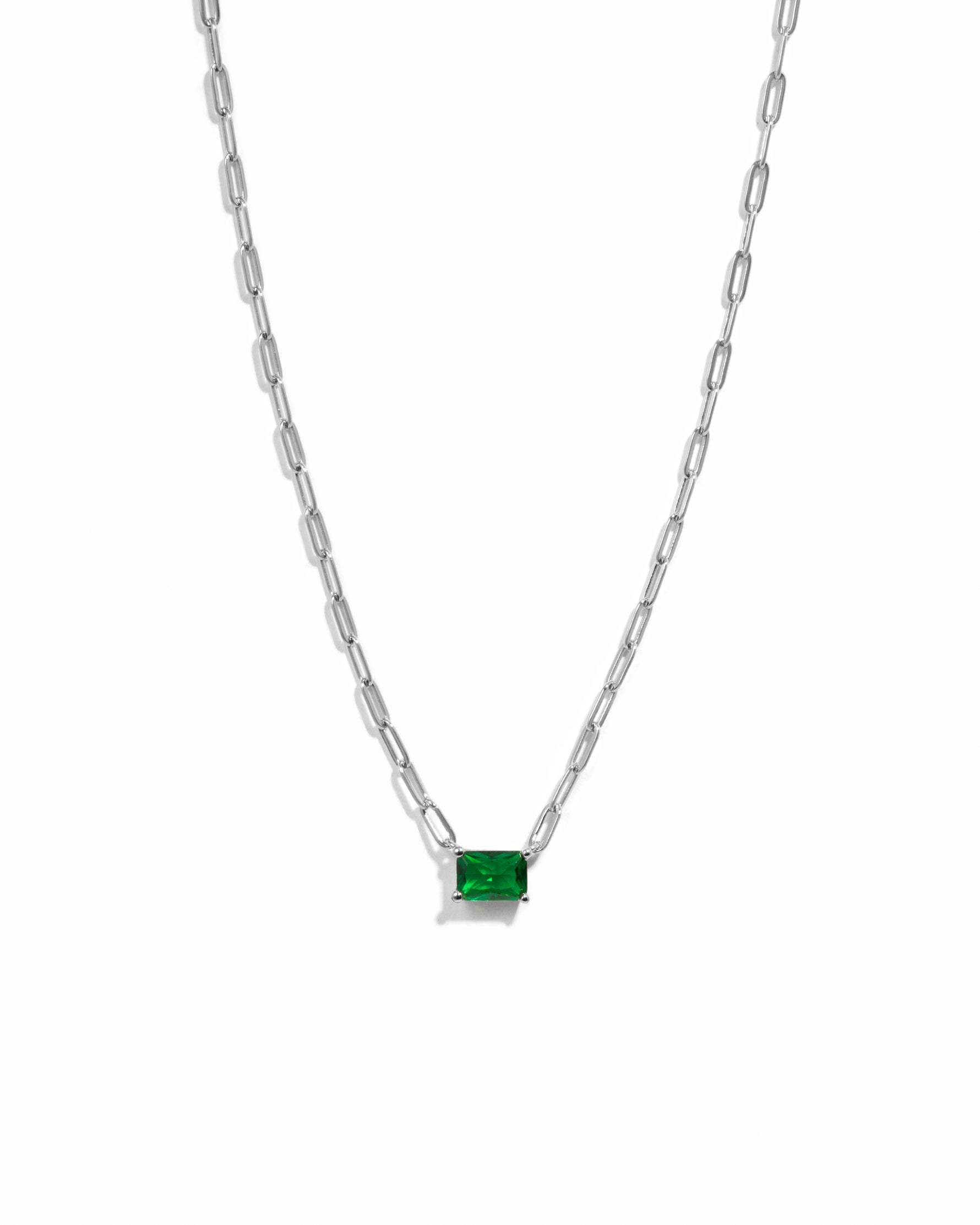 Silver paperclip chain with emerald pendant on white background