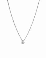 Silver chain necklace with pear pendant on a white background 