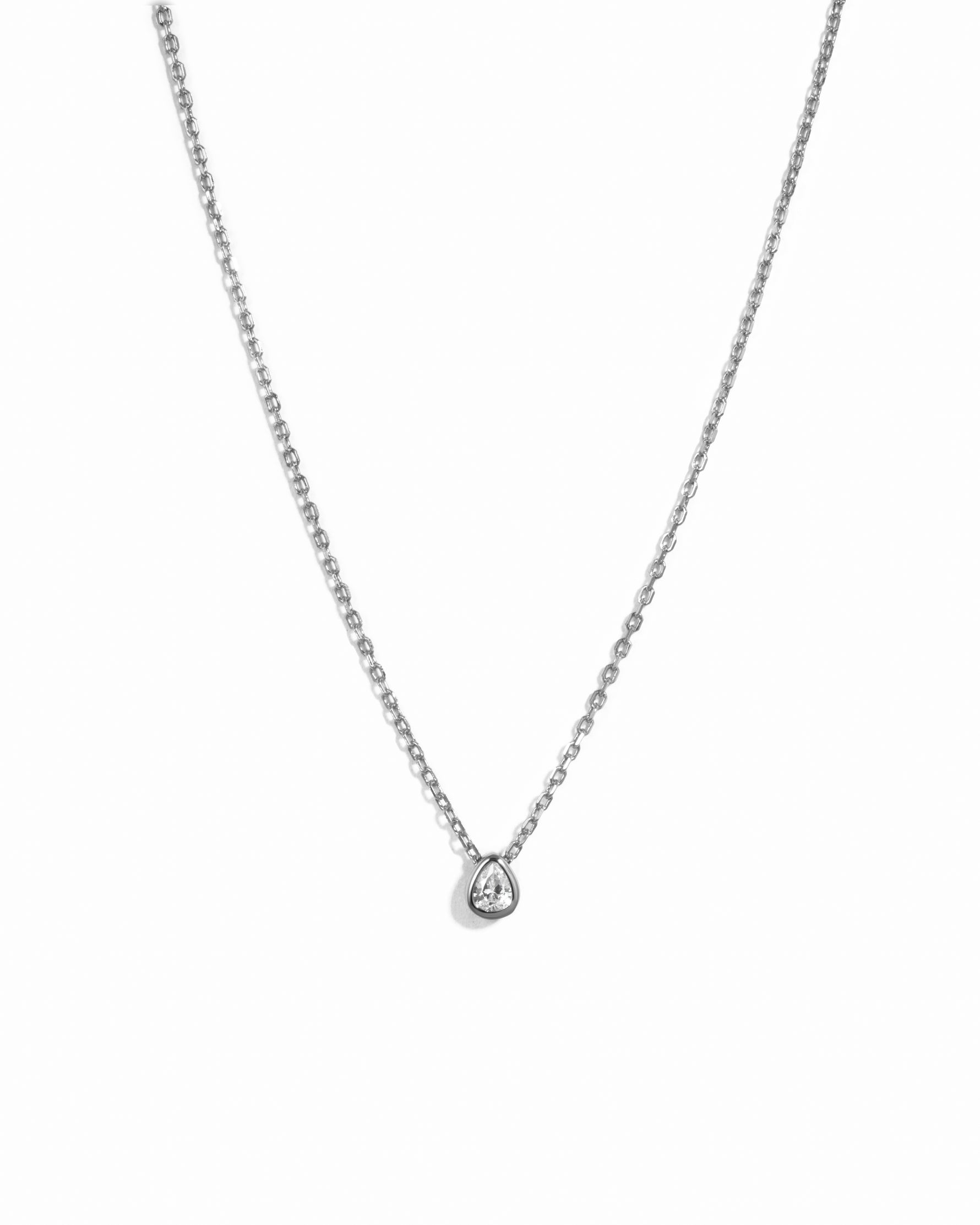 Silver chain necklace with pear pendant on a white background 