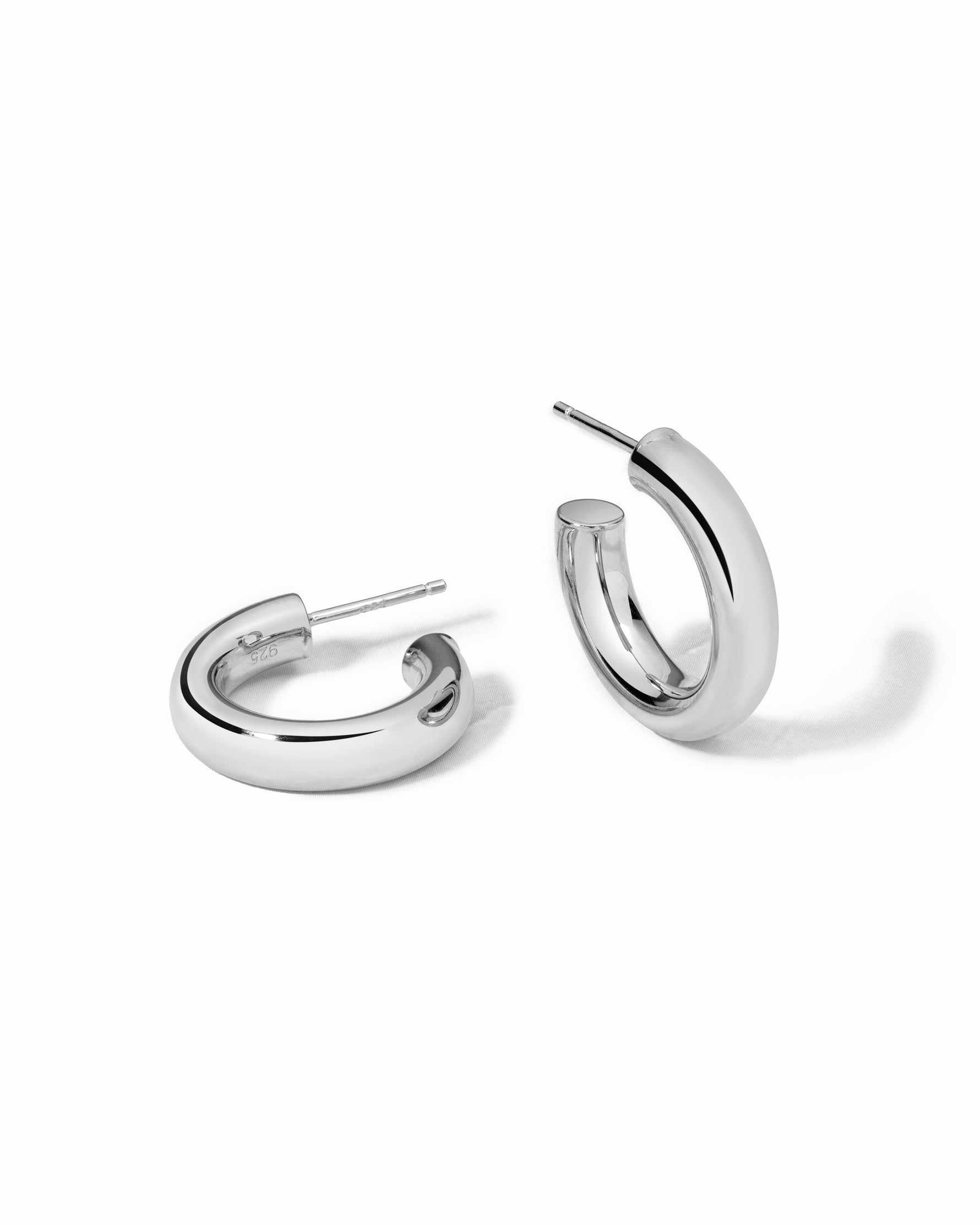 Silver statement hoop earrings on a white background