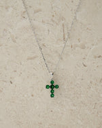 Minimalist necklace with a cross pendant on a beige background