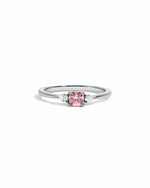 Silver ring with a pink gemstone on a white background
