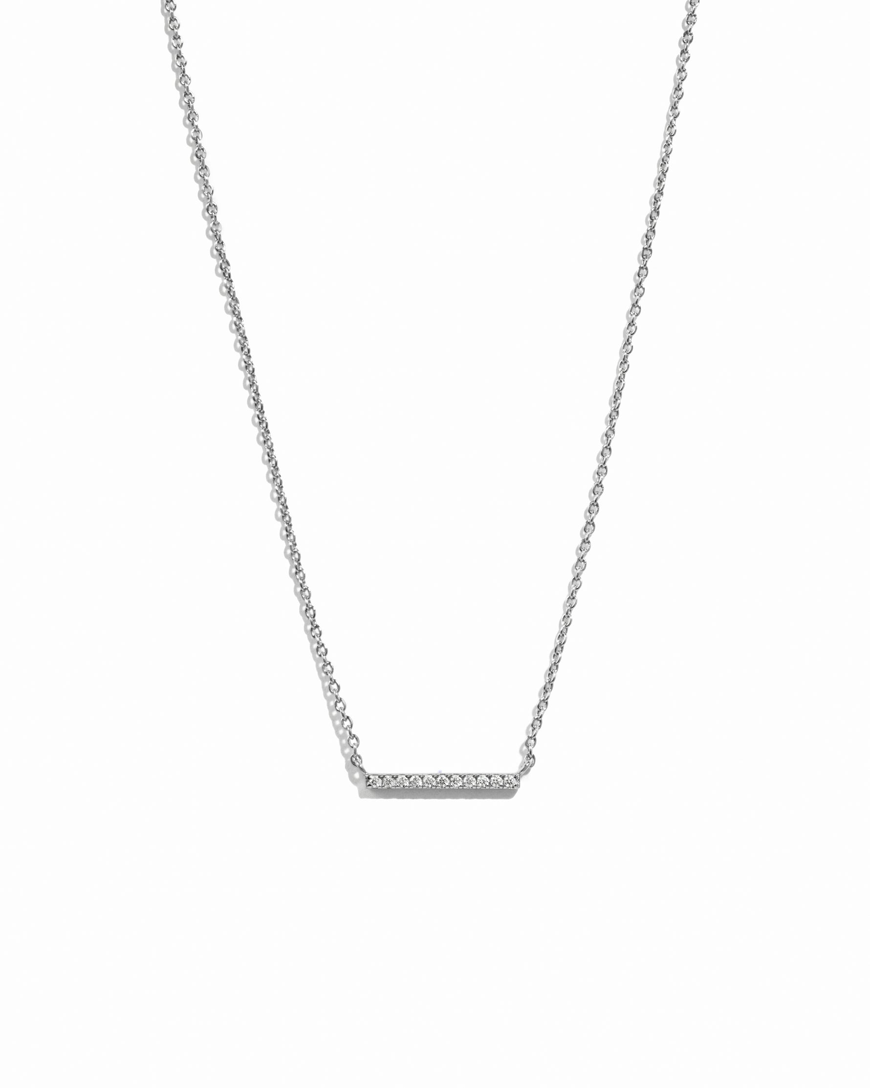 Silver necklace with a bar pendant on a white background
