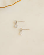 Sterling silver cubic zirconia earrings laying on its side on a plain background