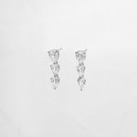 close up of statement earrings with teardrop shape diamonds set in silver