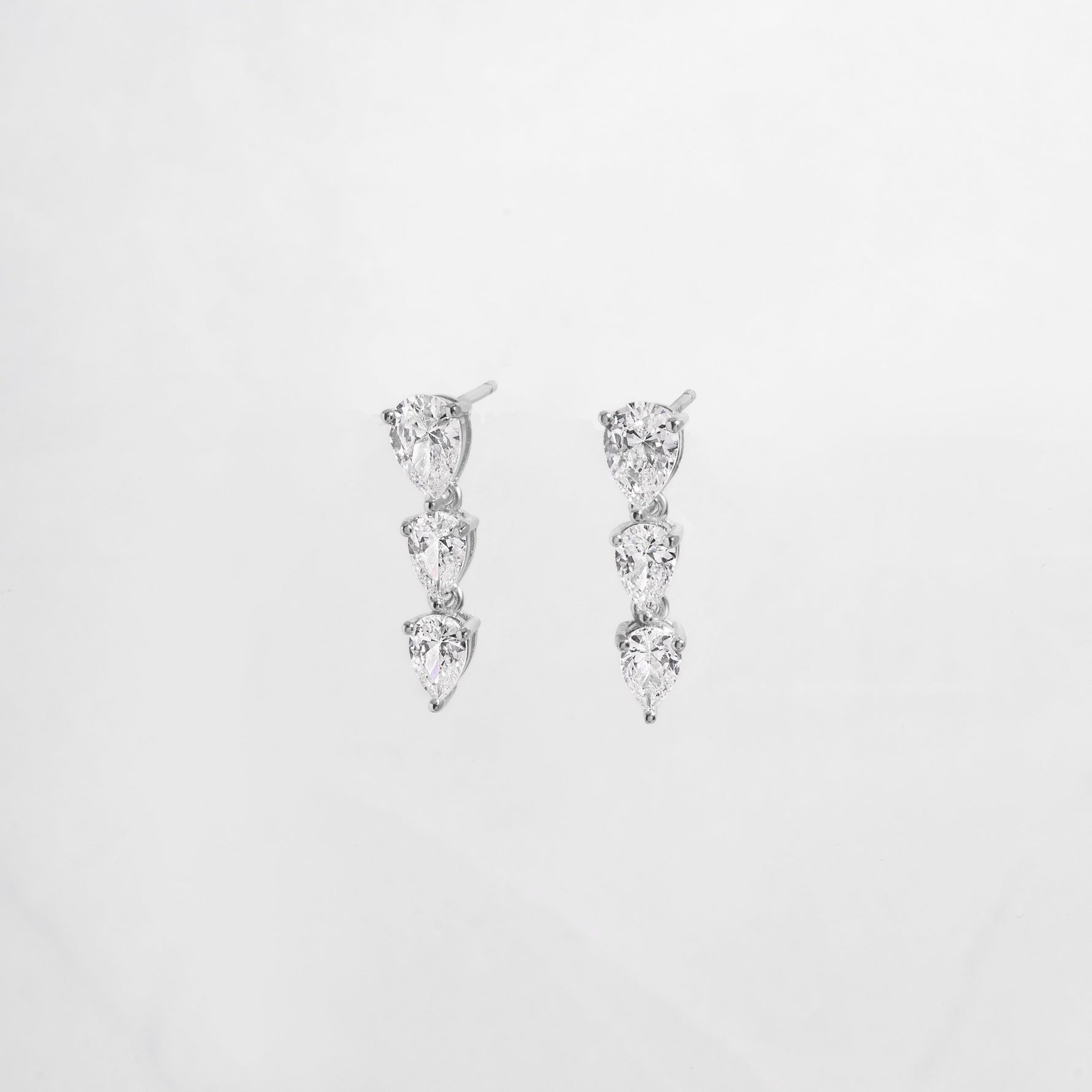 close up of statement earrings with teardrop shape diamonds set in silver