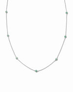 Beaded necklace with emerald green gemstones on a white background