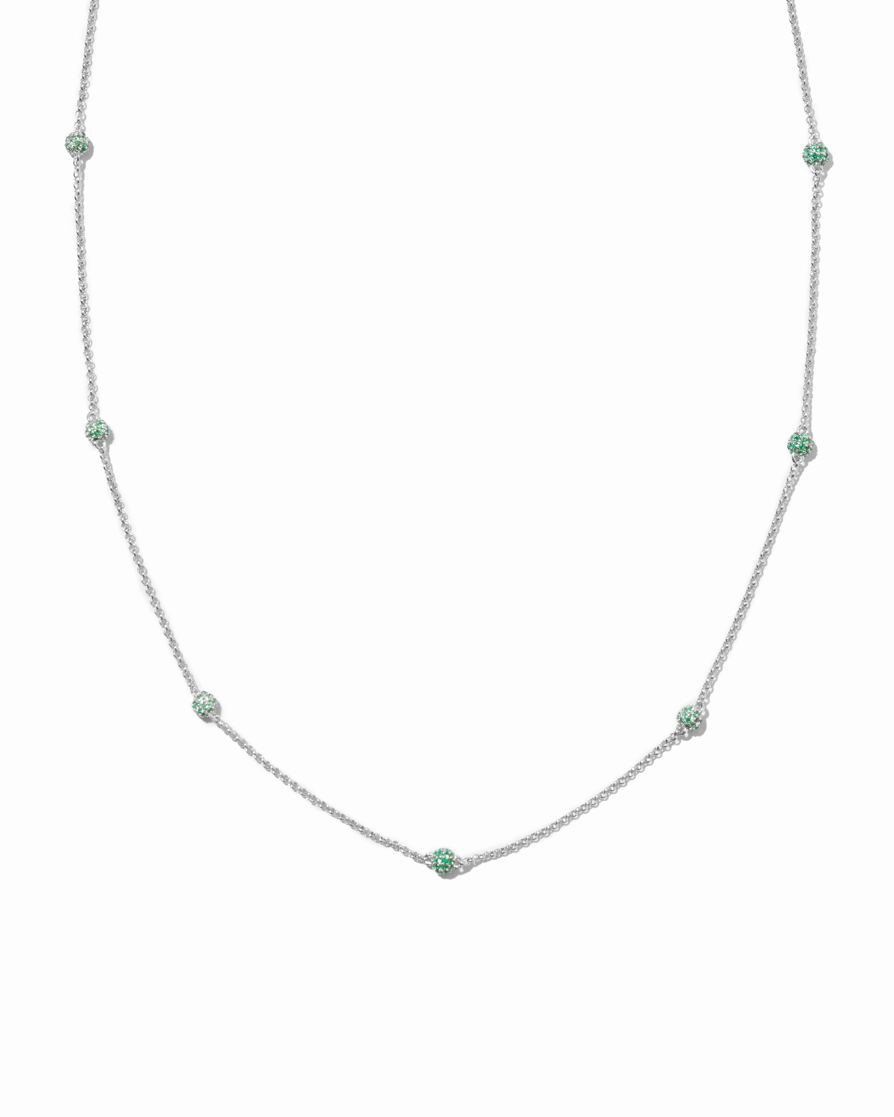 Beaded necklace with emerald green gemstones on a white background