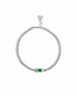 Silver bracelet with a emerald green gemstone on a white background