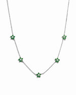 silver flower necklace with emerald green gemstone pendants on a white background