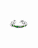 Silver ear cuff with green gemstones on a white background