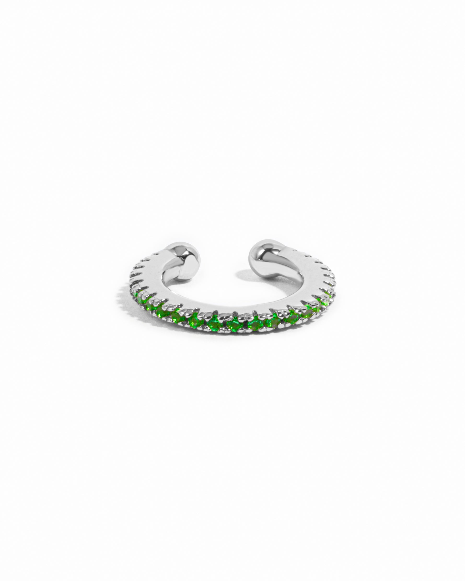 Silver ear cuff with green gemstones on a white background