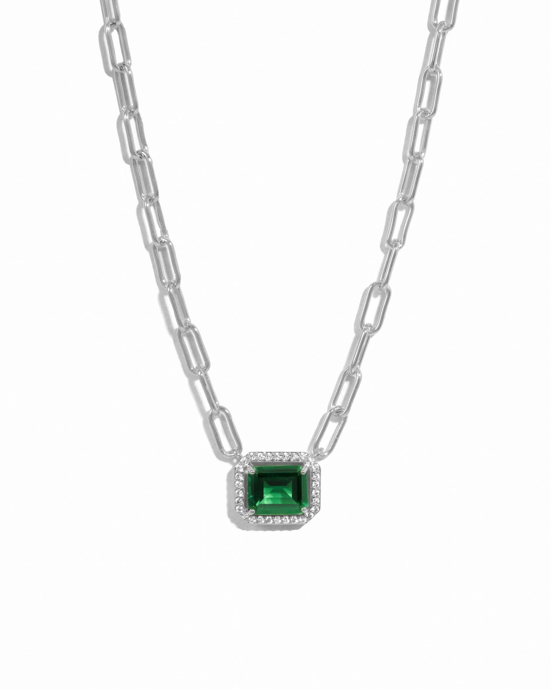 silver paperclip chain necklace with a emerald green gemstone pendant on a white background