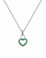 Heart-shaped pendant with green stones on a silver chain against a white background