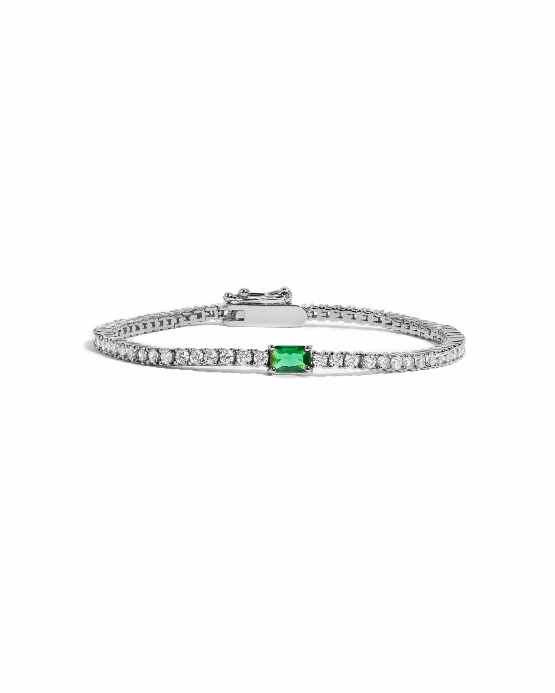silver tennis bracelet with emerald green baguette center stone