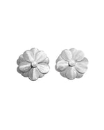 closeup of statement earrings featuring silver flower earrings