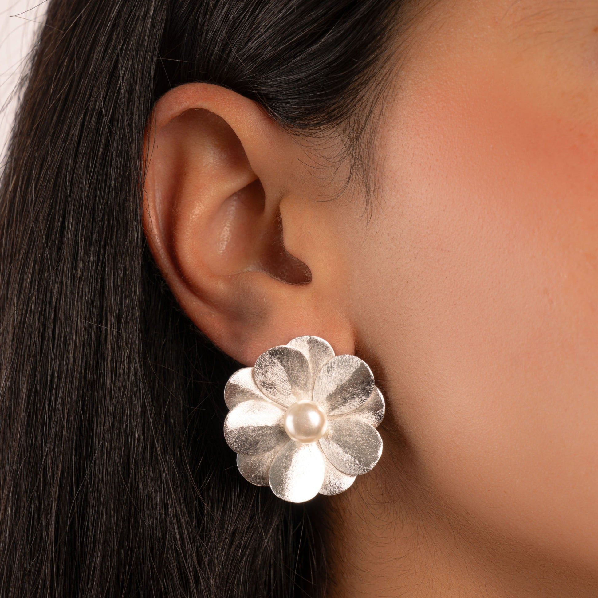 model wearing silver flower statement earrings