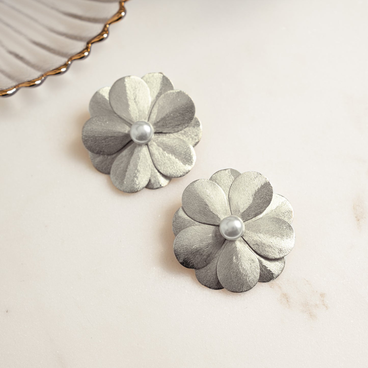 closeup image of statement earrings for the summer featuring a flower earring design